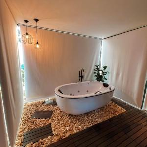 La salle de bains est pourvue d'une baignoire sur un lit de rochers. dans l'établissement Fazenda Hirt, à Três Coroas