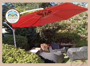 einen roten Regenschirm und ein paar Stühle und einen Tisch in der Unterkunft Cabana Alpinas del Parque in General Belgrano + 6 Fotos