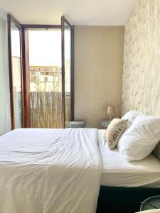 a bedroom with a large white bed with a window at CHARMANT APPARTEMENT AVEC GRANDE CAPACITÉ D’ACCUEIL in Saint-Jacques-de-la-Lande