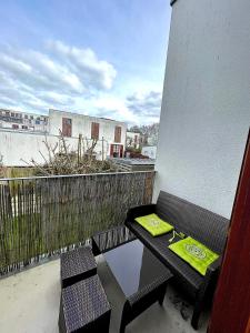 a balcony with a table and chairs on a balcony at CHARMANT APPARTEMENT AVEC GRANDE CAPACITÉ D’ACCUEIL in Saint-Jacques-de-la-Lande