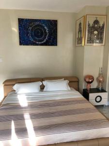 ein Schlafzimmer mit einem großen Bett und einem Gemälde an der Wand in der Unterkunft Hollywood Art Studio Apartment in Los Angeles