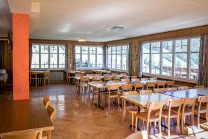 KernsにあるHotel Alpenhofのダイニングルーム(テーブル、椅子、窓付)