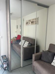 sala de estar con espejo y sofá en la rafale, en Fort-Mahon-Plage