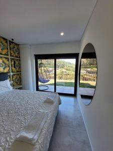 - une chambre avec un lit et un miroir rond dans l'établissement Quinta do Bento, à Vieira do Minho