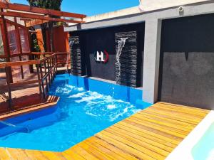 a swimming pool with a wave mural on a house at Firenze Apartments in Necochea
