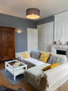 uma sala de estar com um sofá e uma mesa em Appartement 1er étage Villa Isabelle em Allevard