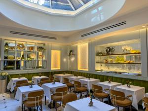 a dining room with tables and chairs and a skylight at Iroquois New York Times Square in New York