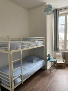 a bedroom with two bunk beds and a table at Appartement 1er étage Villa Isabelle in Allevard