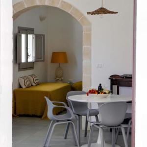 um quarto com uma mesa e cadeiras e uma cama em Masseria Pezze Galere Piscina privata em Montalbano