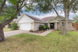 a house with a garage and trees in a yard at McAllen 4BR with Pool, Shopping & More in McAllen