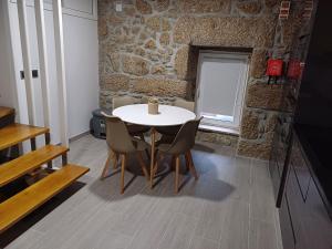 una mesa y sillas en una habitación con una pared de piedra en Casa da Póvoa, en Seia