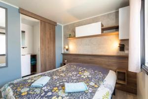 a bedroom with a bed with two towels on it at MOBILHOME SOLEIA NEUF 2023 MAR ESTANG SIBLU VILLAGE Canet-en-Roussillon in Canet-en-Roussillon