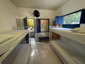 um quarto com 2 beliches e um relógio na parede em Ooxe Hostel em Itacaré