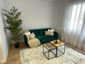 sala de estar con sofá verde y mesa en ByAndreea Apartaments EtxeBi, en Guernica y Luno
