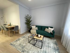 sala de estar con sofá verde y mesa en ByAndreea Apartaments EtxeBi, en Guernica y Luno