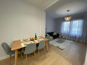 uma sala de jantar e sala de estar com mesa e cadeiras em ByAndreea Apartaments EtxeBi em Guernica y Luno