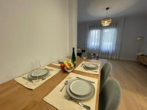una mesa de comedor con platos y copas de vino en ByAndreea Apartaments EtxeBi, en Guernica y Luno