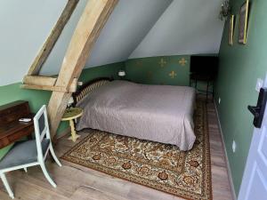 een slaapkamer met een bed in een kamer met groene muren bij La Perchonniere in Mamers
