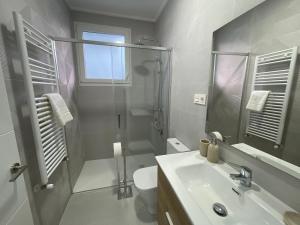 y baño con ducha, aseo y lavamanos. en ByAndreea Apartaments EtxeBi, en Guernica y Luno
