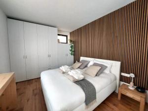 een slaapkamer met een groot wit bed met kussens bij Loft del Talvera 2 in Bolzano
