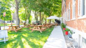 a row of wooden picnic tables next to a building at Auberge de Jeunesse des Balcons in Baie-Saint-Paul