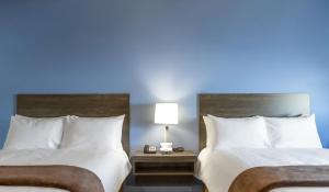 2 camas en una habitación de hotel con una pared azul en My Place Hotel-Las Vegas South/Henderson, NV, en Las Vegas