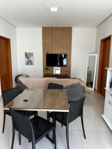 a living room with a table and chairs and a tv at Casa 05 Dona D. PX A JK in Palmas