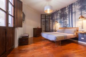 a bedroom with a bed and a wooden floor at Suite Cagliari -101- in Cagliari