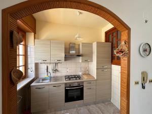 una cocina con un arco con fogones y fregadero en Villa Posillipo, en Marina di Mancaversa