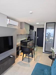 een woonkamer met een televisie en een eetkamer bij Flat #2506 BARRA HOME STAY in Recife