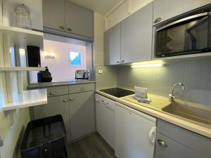 - une cuisine avec des placards blancs et un évier dans l'établissement Appartement Morzine, 3 pièces, 5 personnes - FR-1-754-50, à Morzine