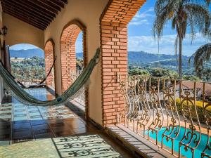 a hammock on the balcony of a house with a view at Chacara com piscina e WiFi em Braganca Paulista SP in Itatiba
