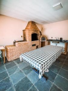 a room with a brick oven with a table at Chacara com piscina e WiFi em Braganca Paulista SP in Itatiba