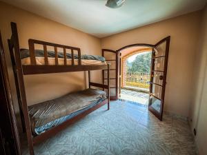 a room with two bunk beds and an open door at Chacara com piscina e WiFi em Braganca Paulista SP in Itatiba
