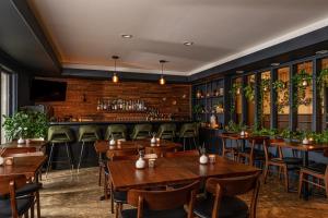 a restaurant with wooden tables and chairs and a bar at The Darby in Beach Lake