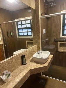 a bathroom with a sink and a shower at Hotel Fazenda Cheiro Verde in Mercês