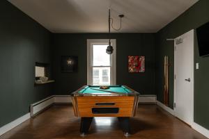 a pool table in a room with green walls at The Darby in Beach Lake