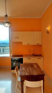 a kitchen with a wooden table and white cabinets and a window at La casa del Mago camere e appartamenti in Pissignano +38 photos