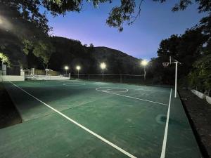 a tennis court at night with lights on at Rancho Huemac in Zimapán