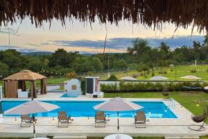 ein großer Pool mit Stühlen und Sonnenschirmen in der Unterkunft Rancho Huemac in Zimapán
