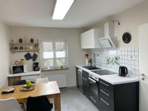 a kitchen with a table and a stove top oven at Ferienhaus Heinrich in Egloffstein