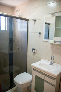 a bathroom with a shower and a toilet and a sink at Smart Cataratas Hotel in Foz do Iguaçu