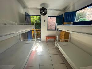 um quarto com 2 beliches e um relógio na parede em Ooxe Hostel em Itacaré
