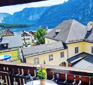 a balcony with a view of a town and a lake at Pension Cafe zum Mühlbach in Hallstatt