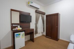 a hotel room with a tv and a refrigerator in a room at فندق رقى المشاعر in Mecca