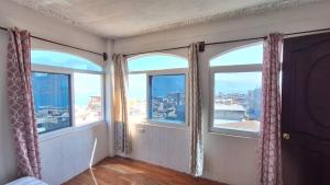 サン・ペドロ・ラ・ラグーナにあるCasa Yelitzaの市街の景色を望む窓3つが備わる客室です。