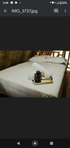 Una foto de una cama con una cámara. en Cabana Encanto., en Ituporanga