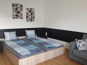 a bedroom with a large bed and a couch at Central Apartman in Salgótarján