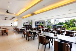 une salle à manger avec des tables et des chaises ainsi qu'une cafétéria dans l'établissement Andakira Hotel - SHA Extra Plus, à Patong Beach