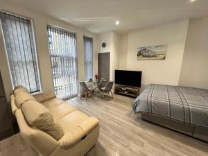 um quarto com um sofá, uma cama e uma mesa em El Murrino Apartments em Bournemouth